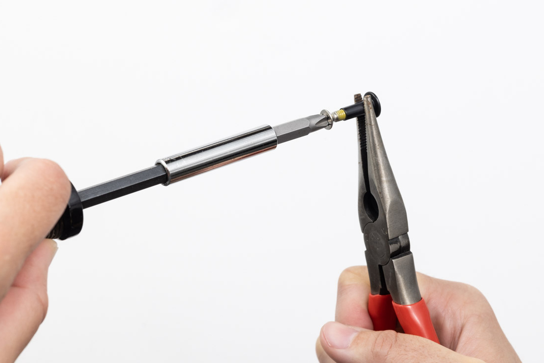 Photo of using pliers to prepare thread locker on Enigma screws.