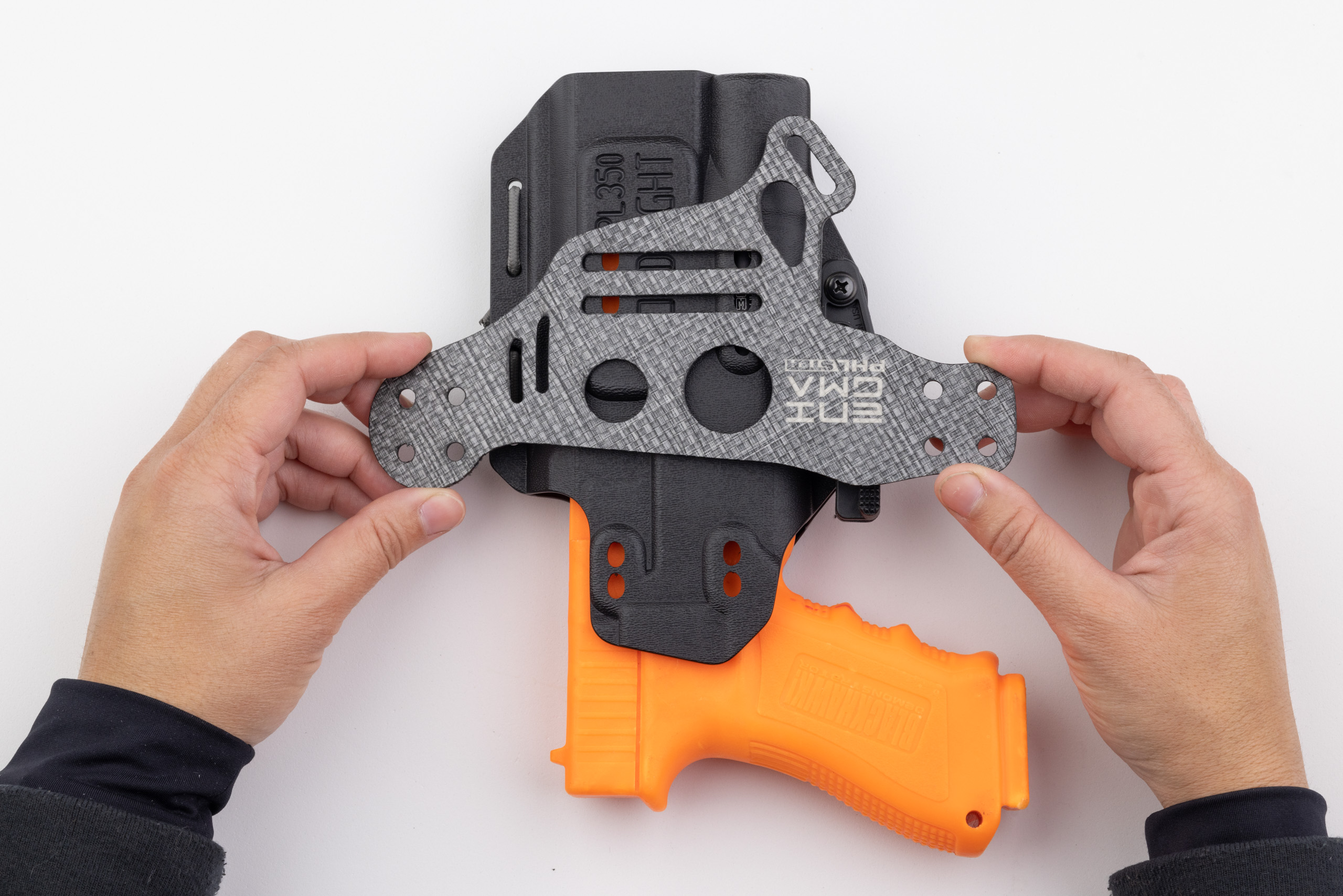 Photo of Light Bearing Enigma faceplate sitting on top of holster.