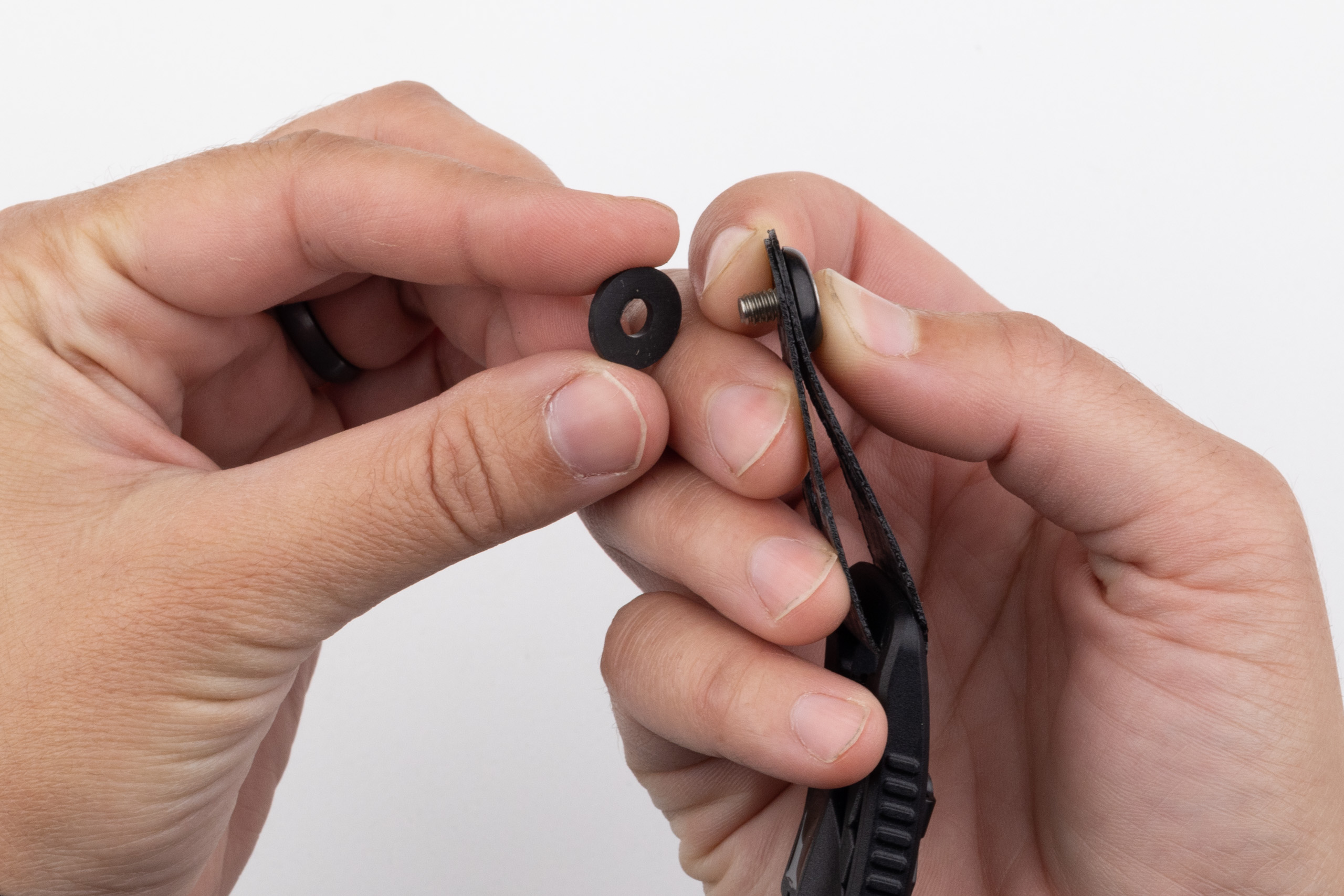 Photo of rubber washer being installed behind belt end.