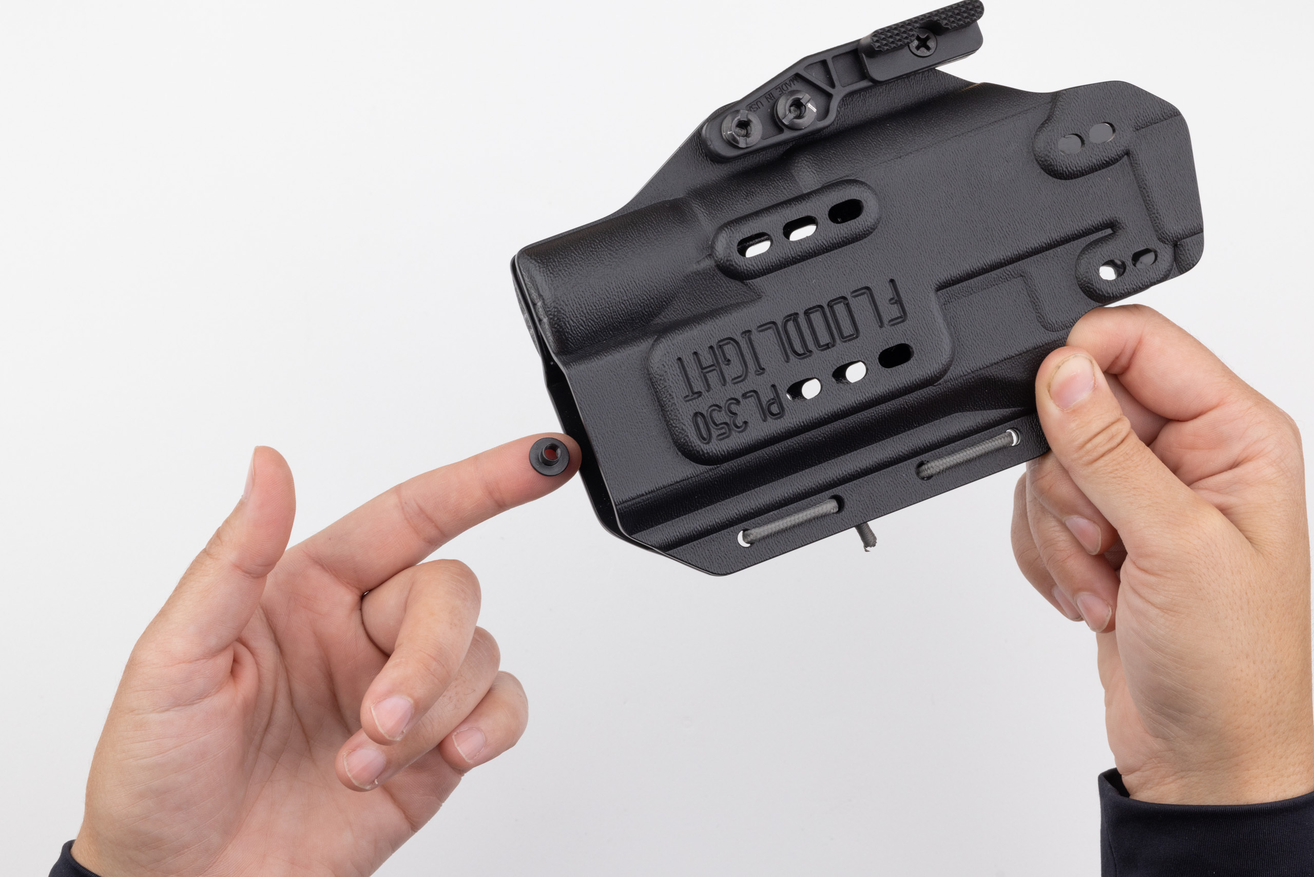 Photo of screw post balanced on finger tip for insertion into holster.