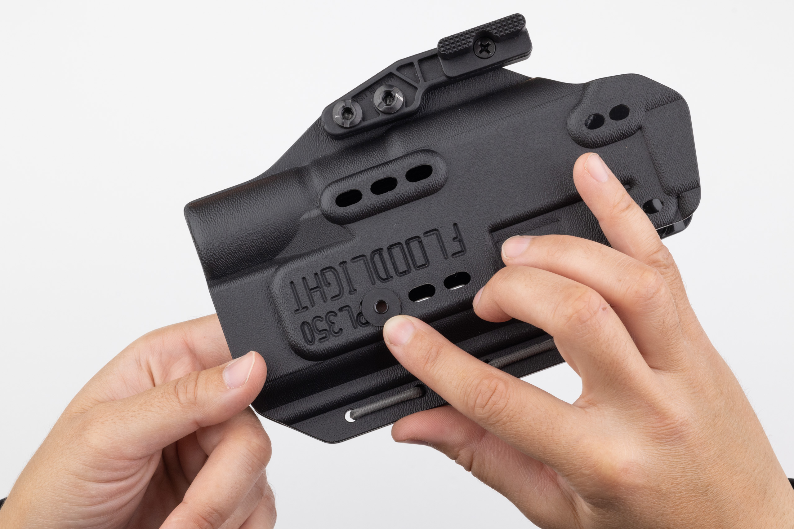 Photo of reaching inside holster to insert screw post.