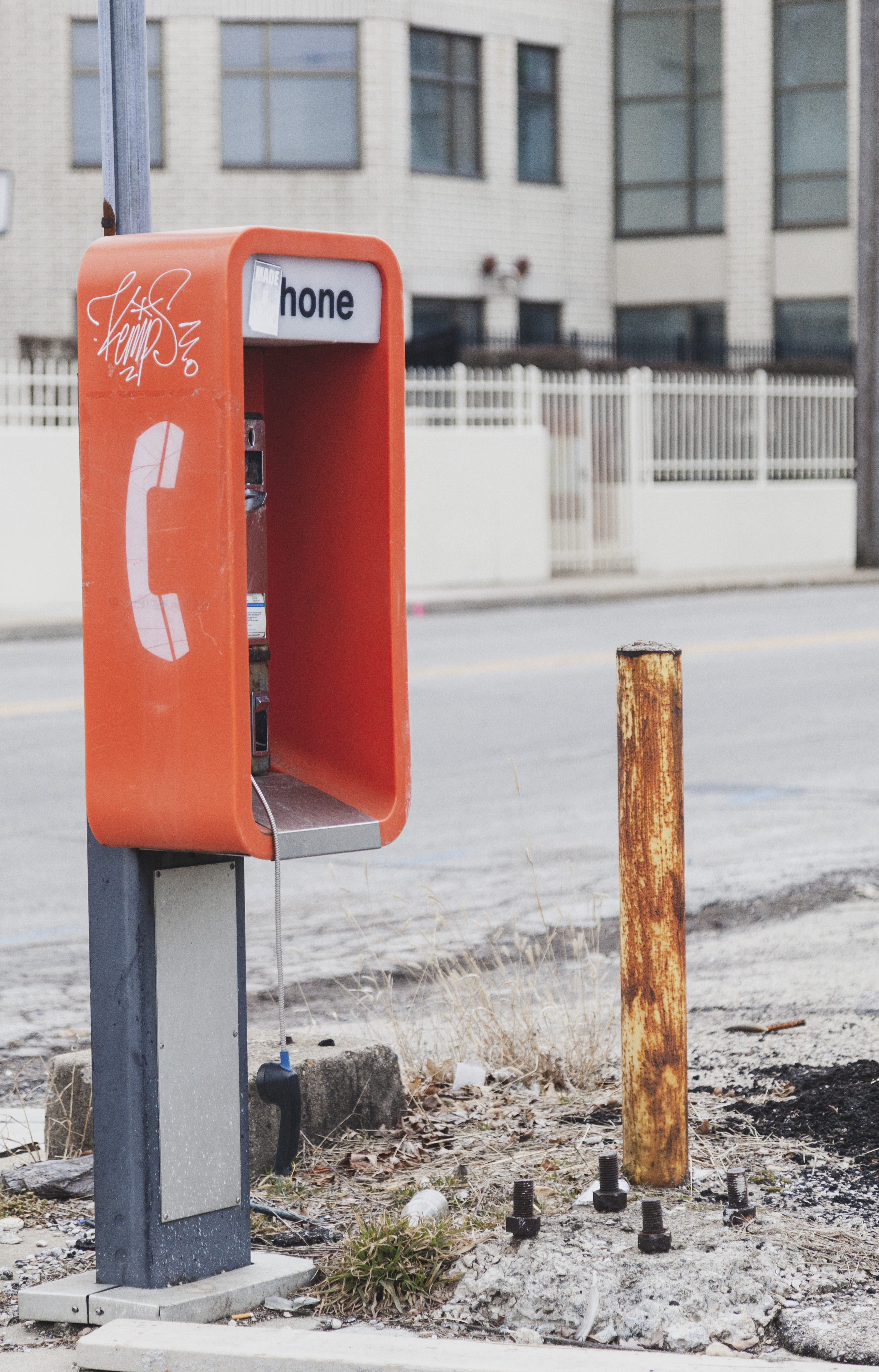 The pay phone is clearly long-broken. Further, the house of worship across the street has a security fence around it. Probably not the greatest neighborhood.