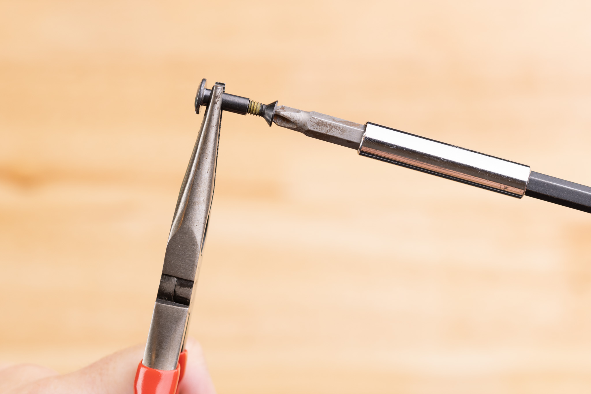 Photo of using pliers to prepare Enigma screws.