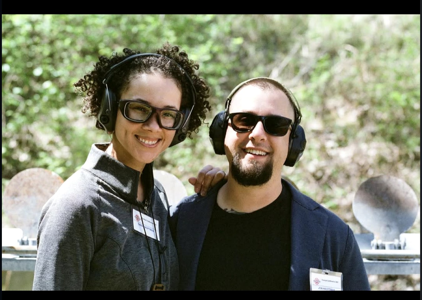 PHLster founders Jon and Sarah Hauptman at the range with hearing protection and TacCon instructor badges, both smiling at camera. Photo: Tamara Keel